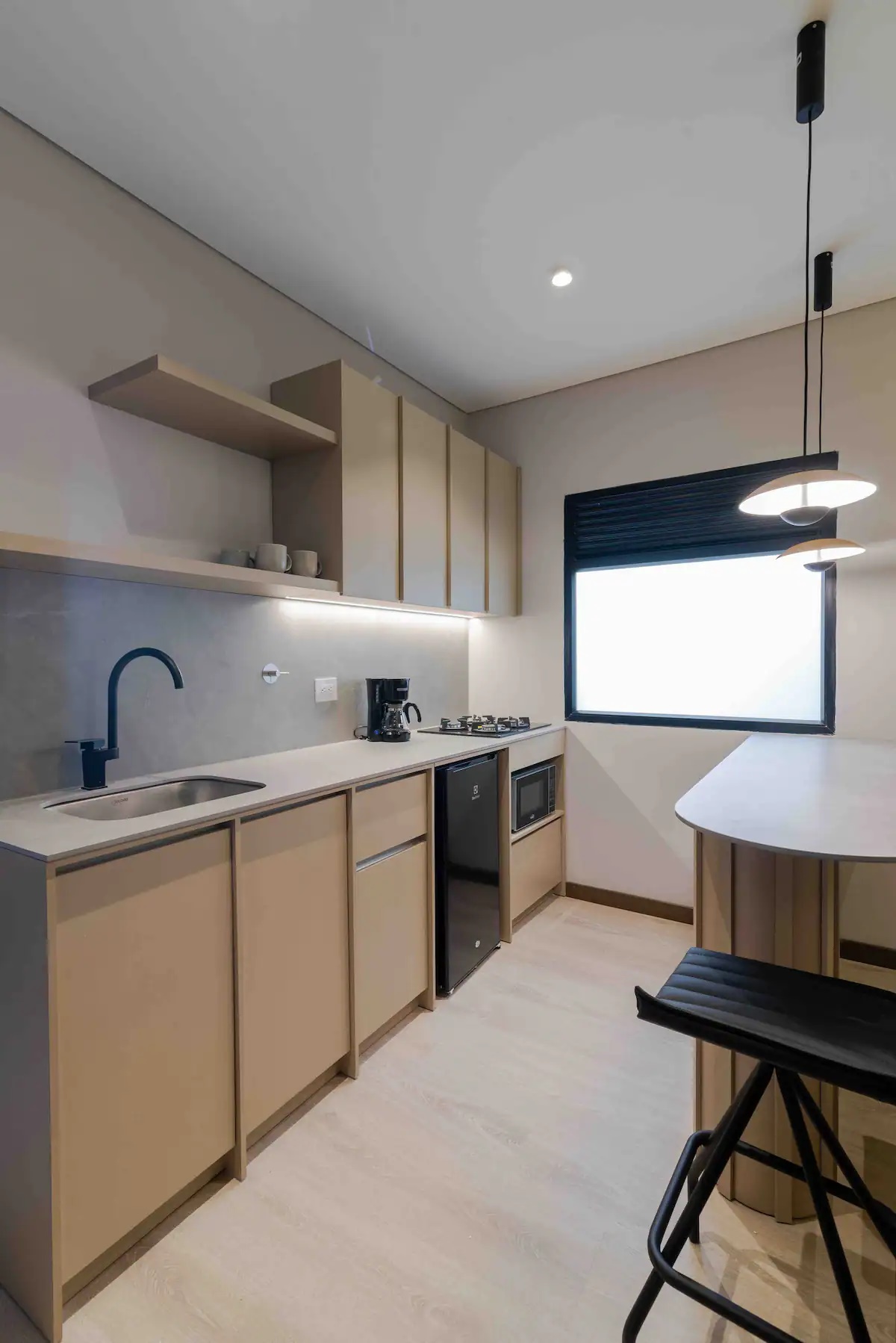 Kitchenette con nevera, microondas, cafetera y barra en apartamento del Hotel Lincoln