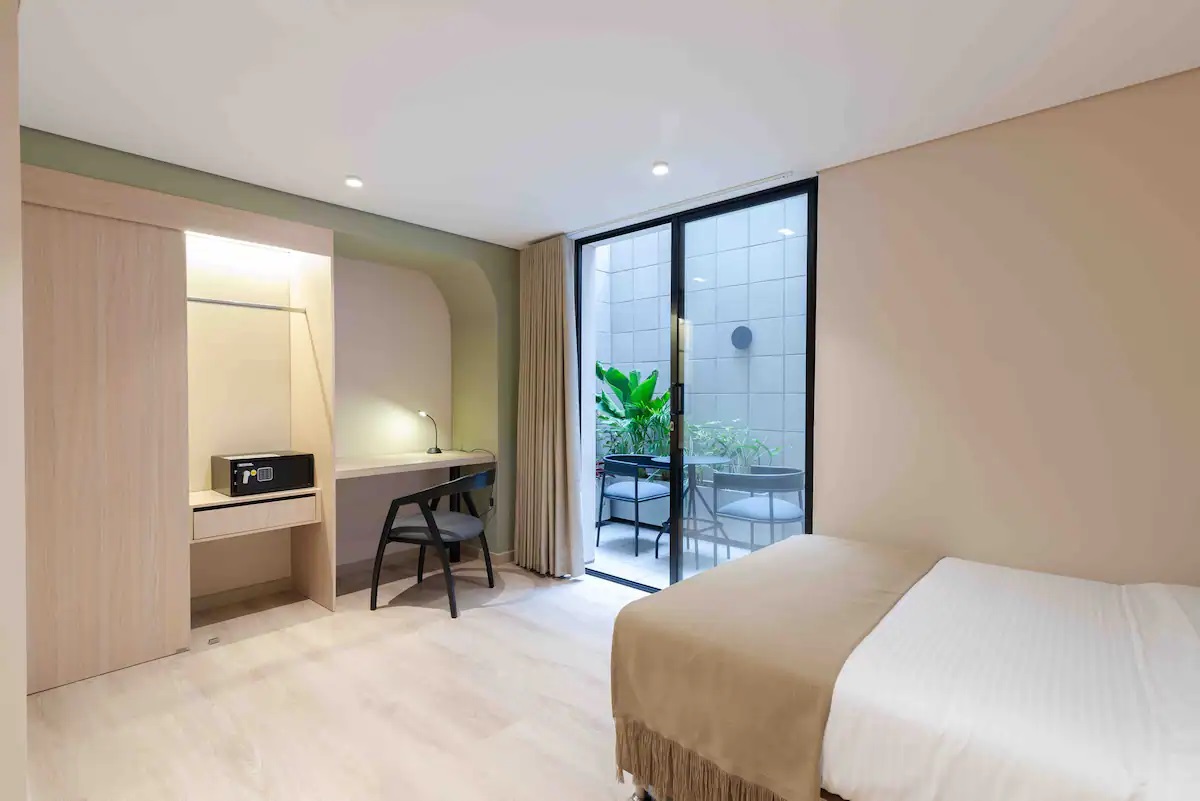Terraza privada con vista interior y zona de descanso en apartamento del Hotel Lincoln