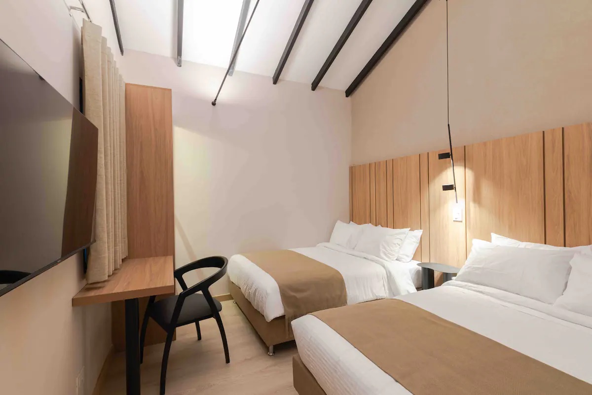 Habitación de apartamento con dos camas, escritorio y Smart TV en el Hotel Lincoln