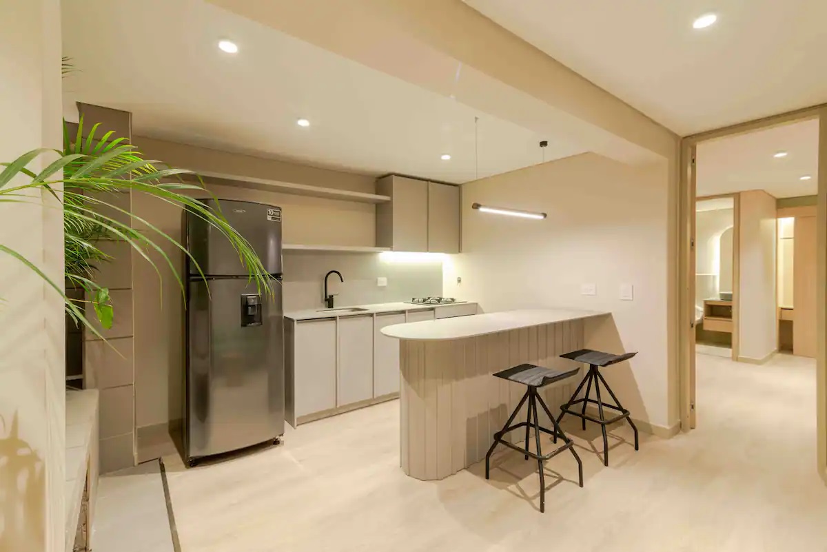 Cocina equipada con barra y nevera en apartamento del Hotel Lincoln