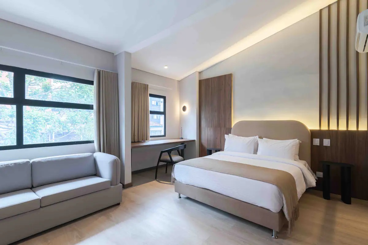 Apartamento con sala de estar, cama queen y escritorio en el Hotel Lincoln