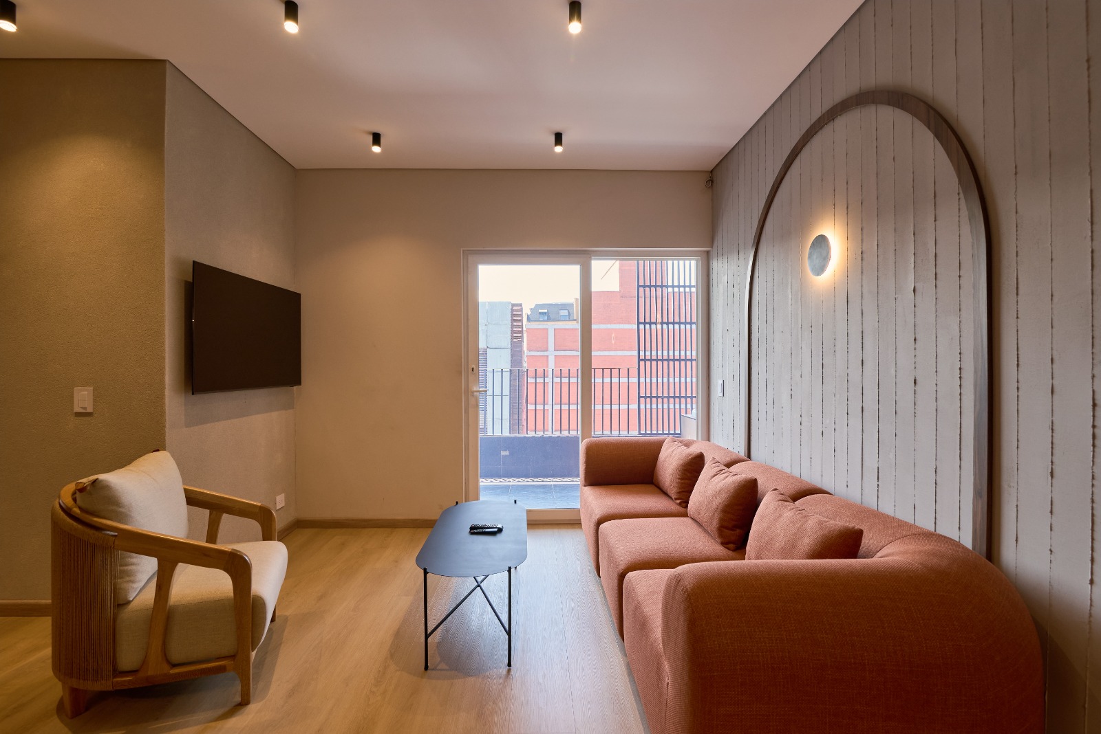 Sala de apartamento con sofá, TV y salida a balcón en el Hotel Lincoln